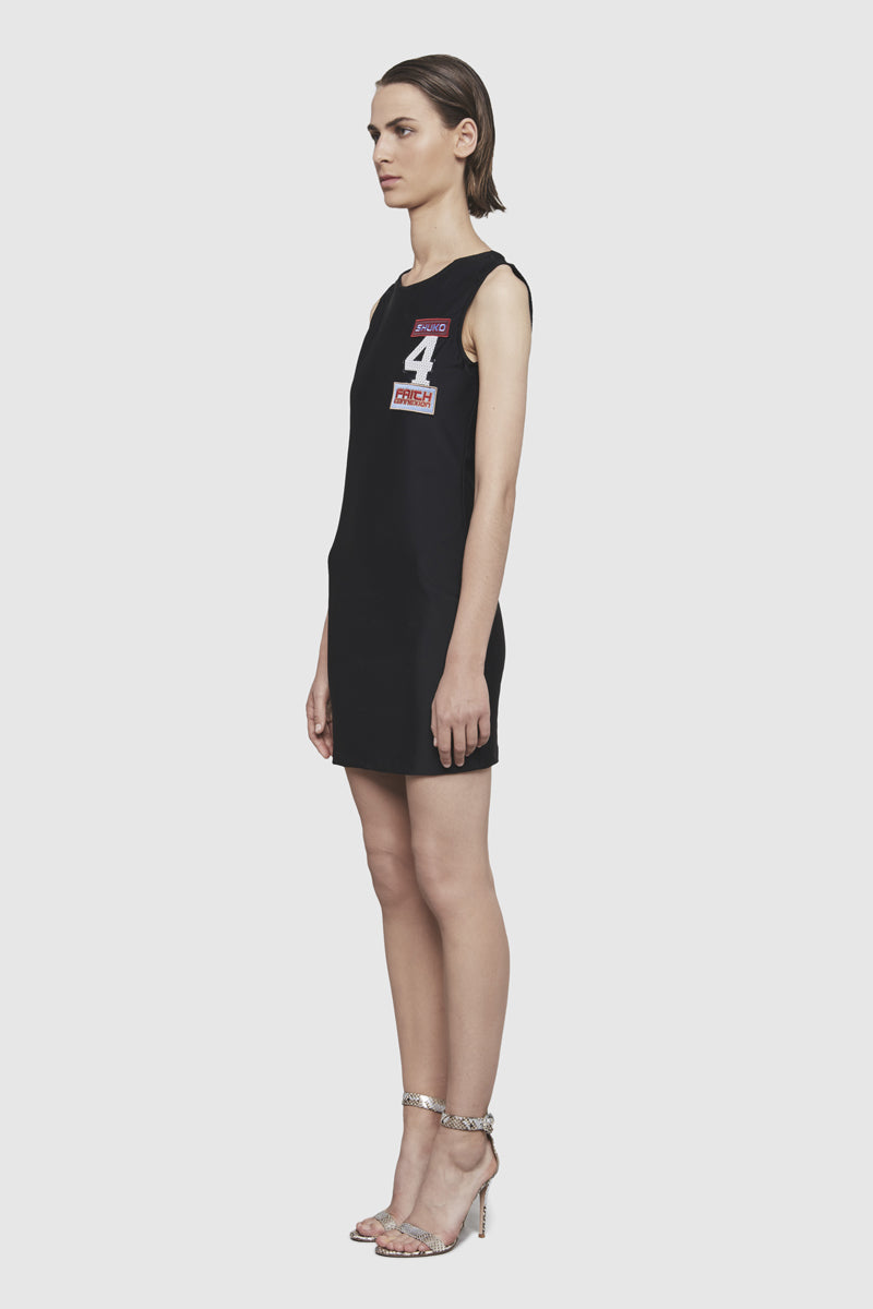 A woman is wearing a Shuko black sleeveless dress by Faith Connexion, a brand of luxury clothes