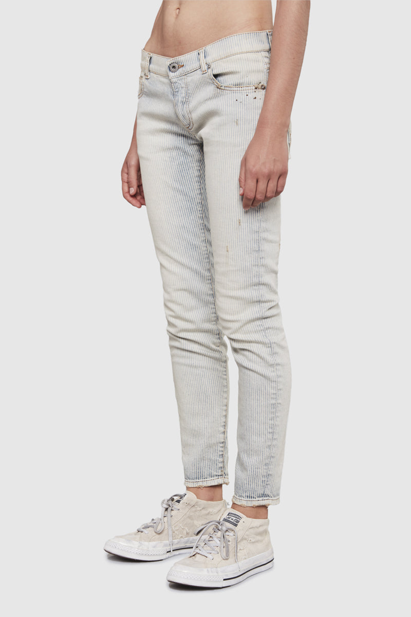 A woman is wearing a stripes denim slim pants by Faith Connexion, a brand of luxury clothes