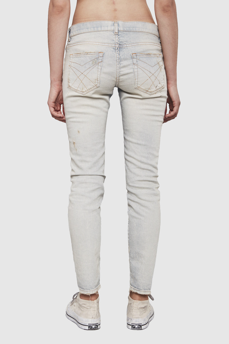 A woman is wearing a stripes denim slim pants by Faith Connexion, a brand of luxury clothes
