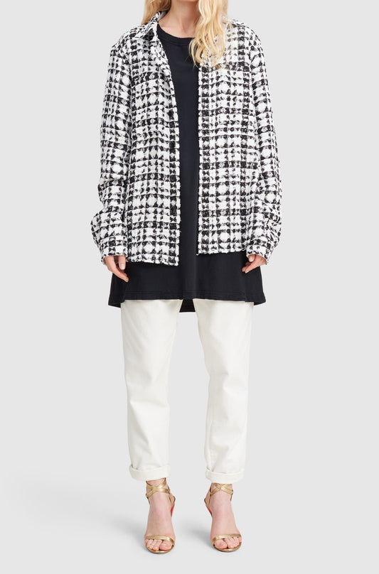 A woman is wearing a black and white checked tweed overshirt by Faith Connexion, a brand of luxury clothes