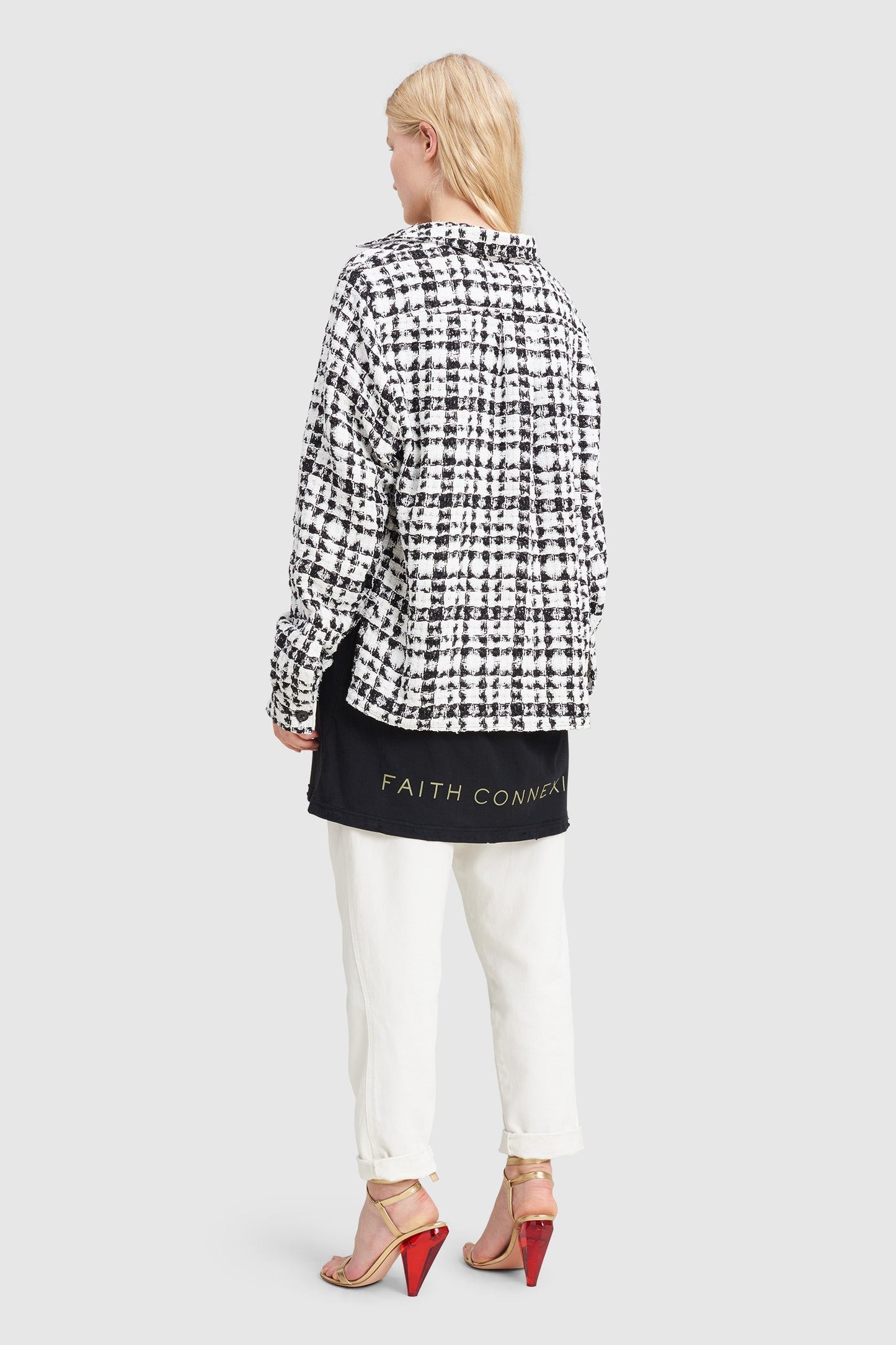 A woman is wearing a black and white checked tweed overshirt by Faith Connexion, a brand of luxury clothes