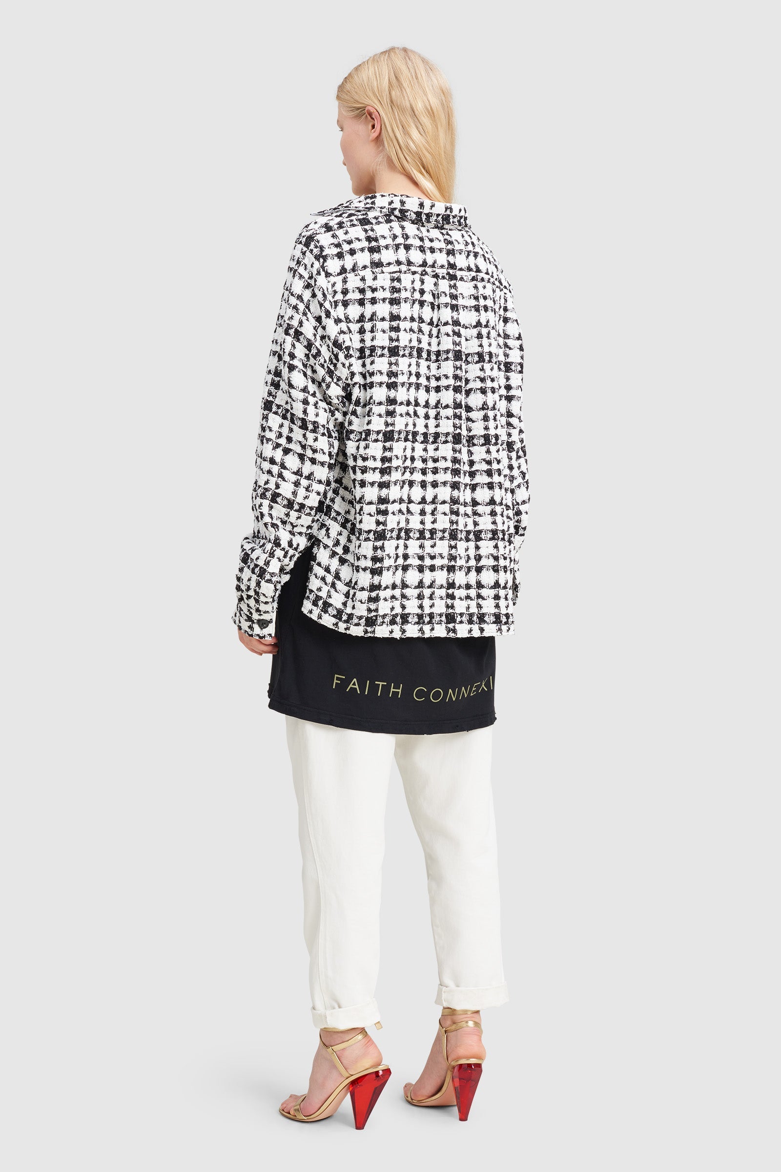 A woman is wearing a black and white checked tweed overshirt by Faith Connexion, a brand of luxury clothes